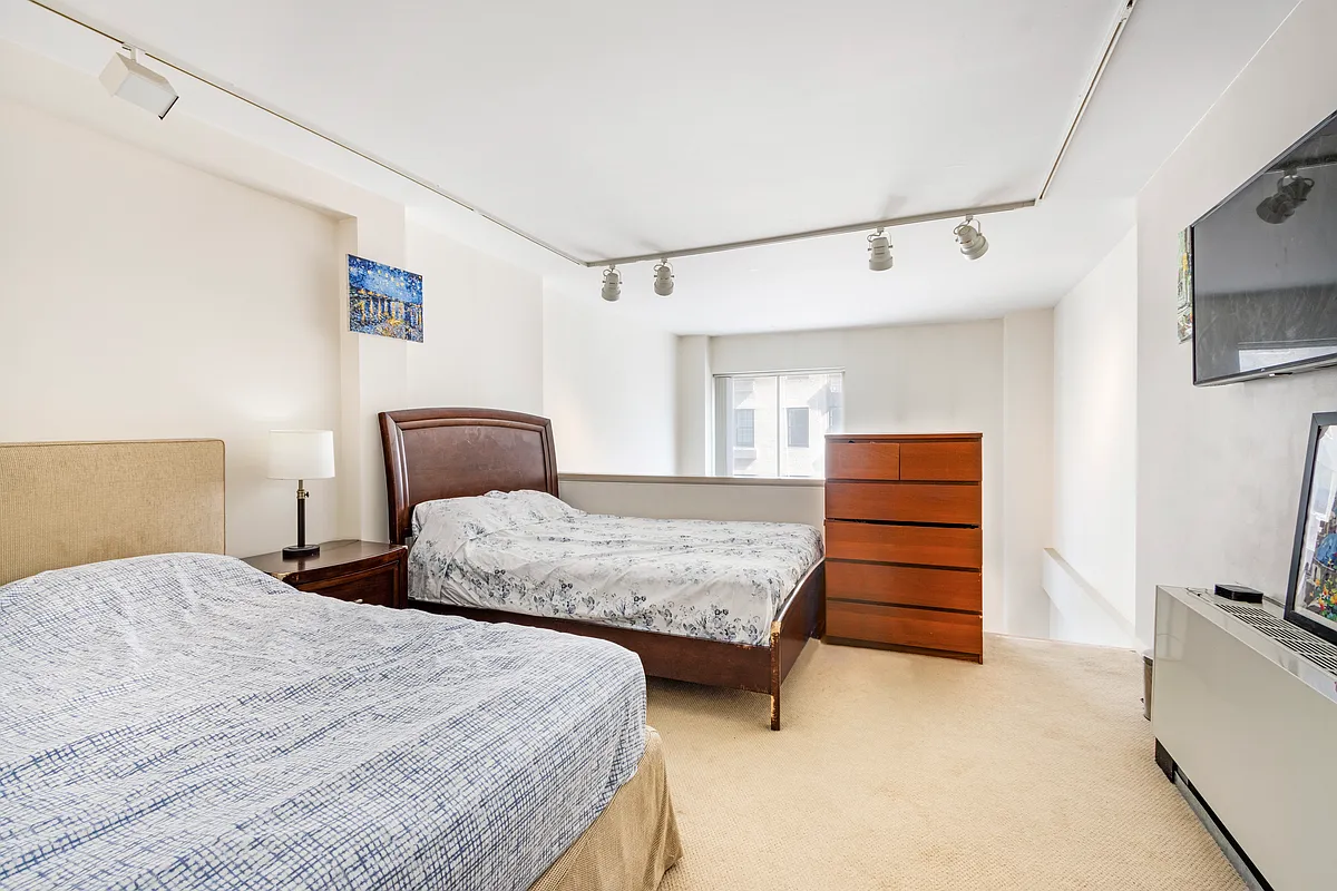 32 East 76th Street, Unit 502 Manhattan, NY 10021 - Photo 4 of 7 a bedroom with a bed and a television