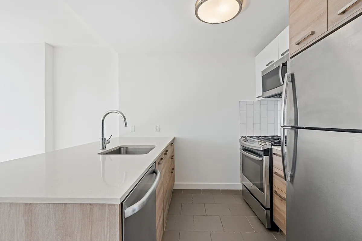 a kitchen with stainless steel appliances granite countertop a sink and a refrigerator