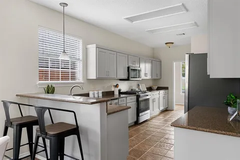 a kitchen with a stove a sink and a refrigerator