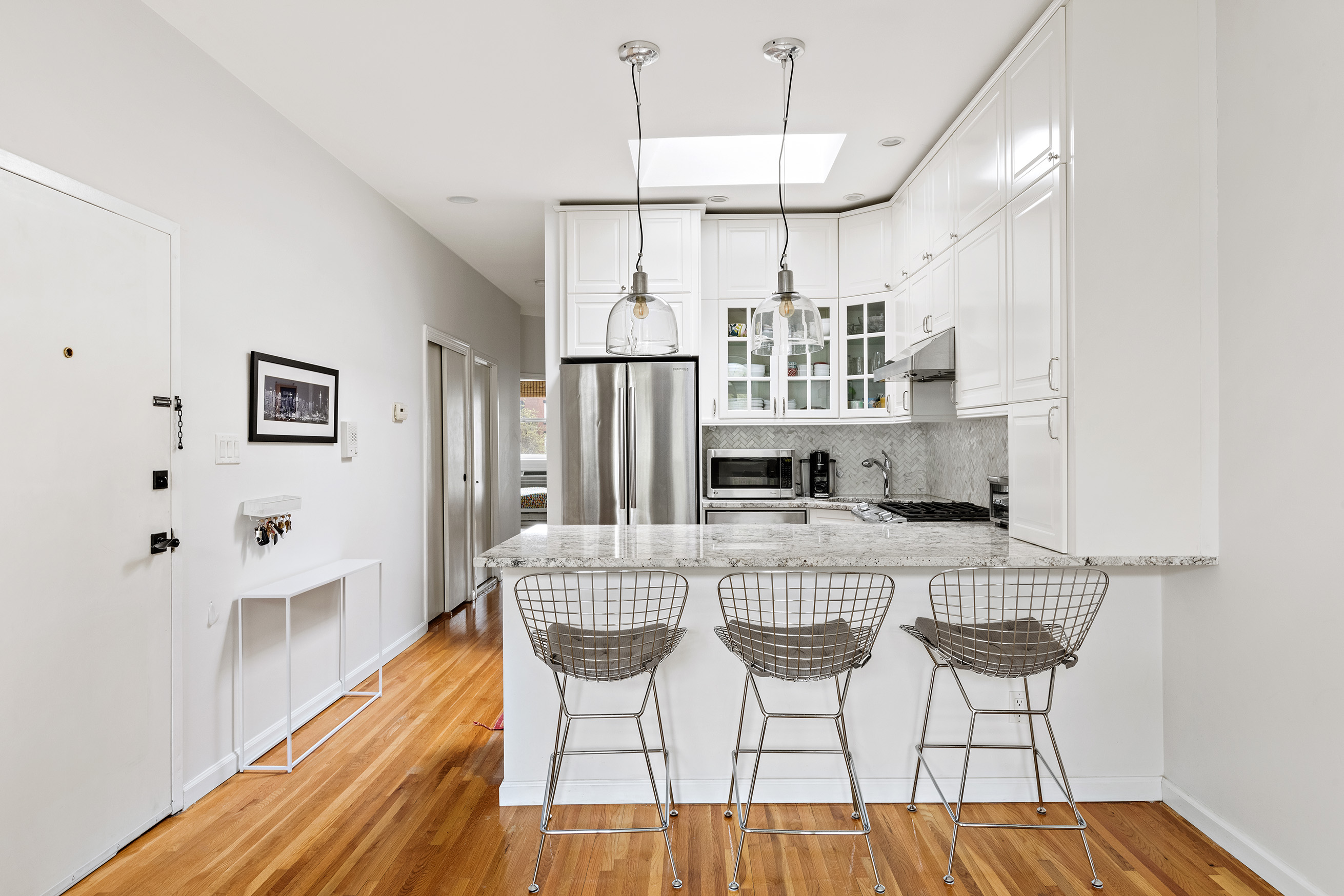 454 12th Street, Unit 3 Brooklyn, NY 11215 - Photo 4 of 18 a kitchen with stainless steel appliances granite countertop a kitchen island a stove a table and chairs in it