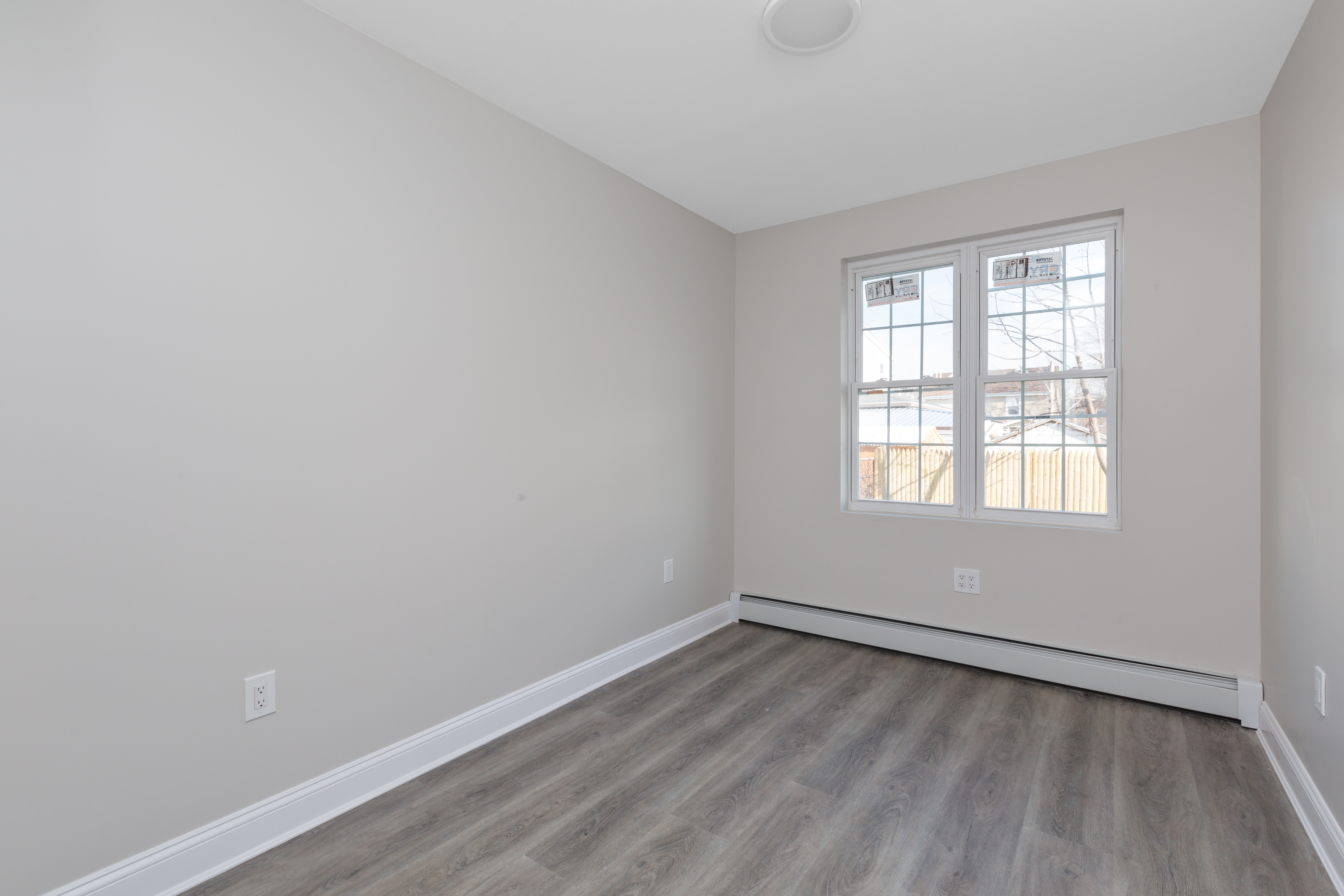 143-10 Shore Avenue Queens, NY 11435 - Photo 13 of 30 wooden floor in an empty room with a window