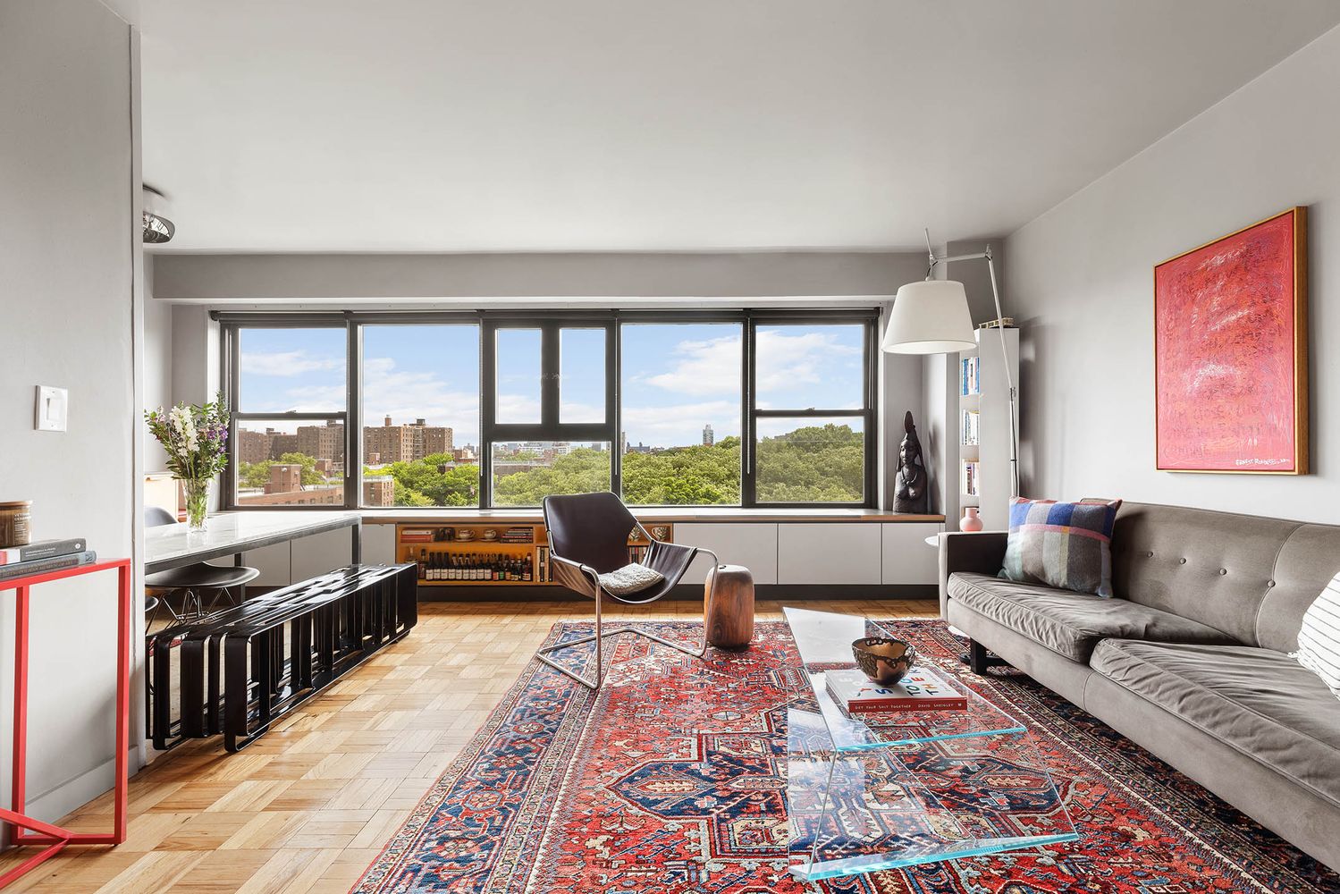 a living room with furniture large windows and wooden floor