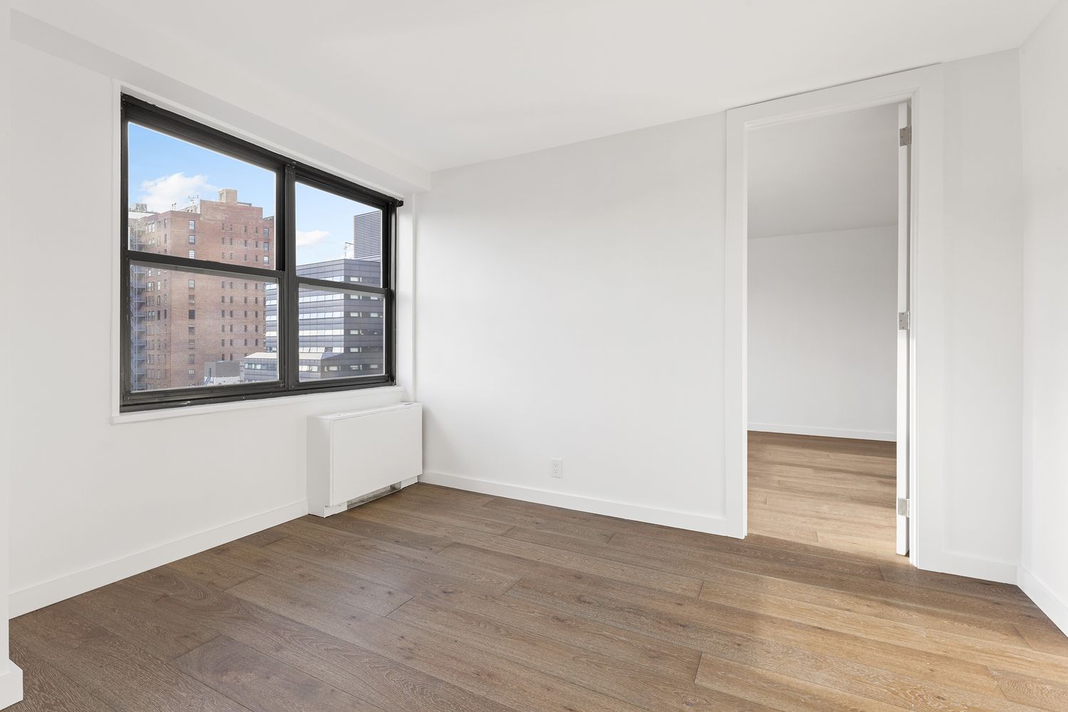 7 East 14th Street, Unit 17RS Manhattan, NY 10003 - Photo 4 of 9 an empty room with wooden floor and windows