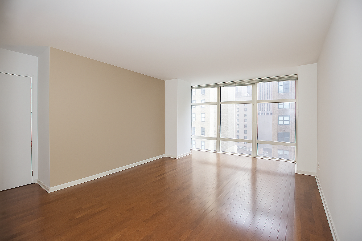 1600 Broadway, Unit 7F Manhattan, NY 10019 - Photo 2 of 7 an empty room with wooden floor and windows