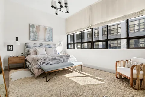 a spacious bedroom with a bed a couch and a table in it