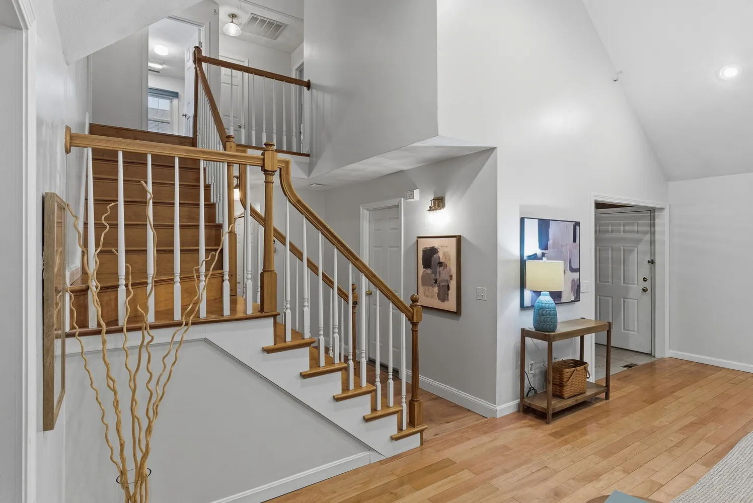a view of staircase with wooden floor and a chandelier
