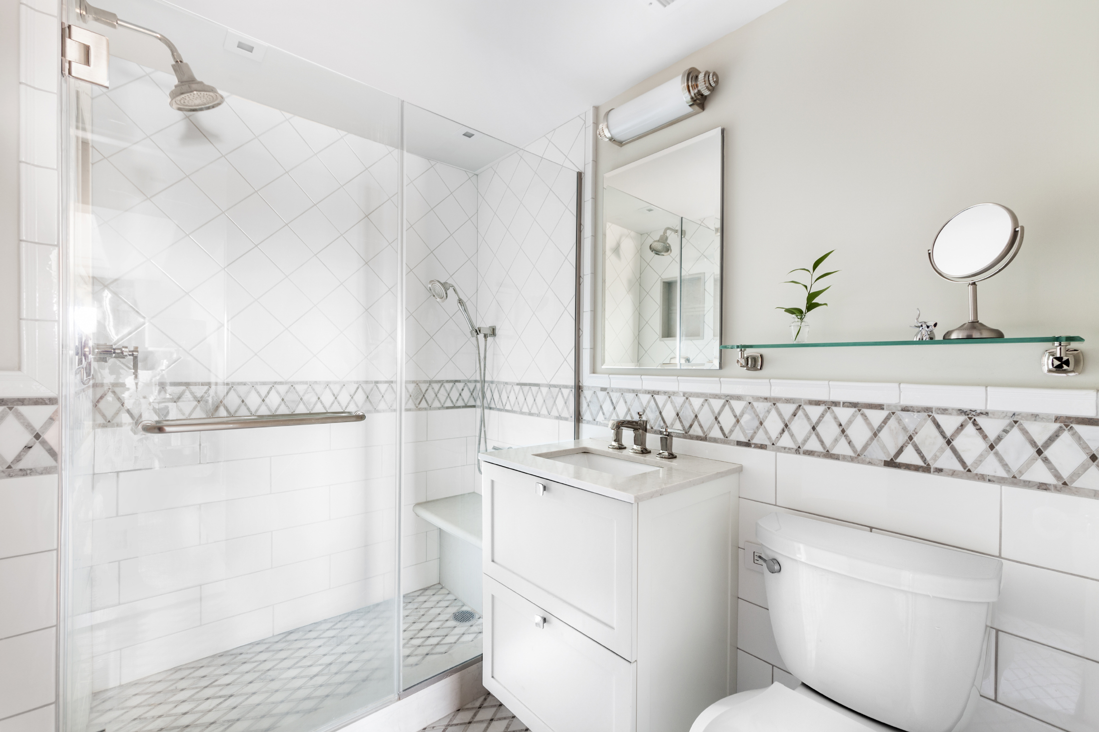 11 5th Avenue, Unit 15H Manhattan, NY 10003 - Photo 6 of 10 a bathroom with a sink a toilet and a mirror