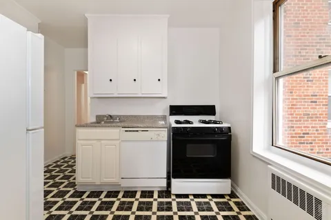 a kitchen with a stove a sink and a window
