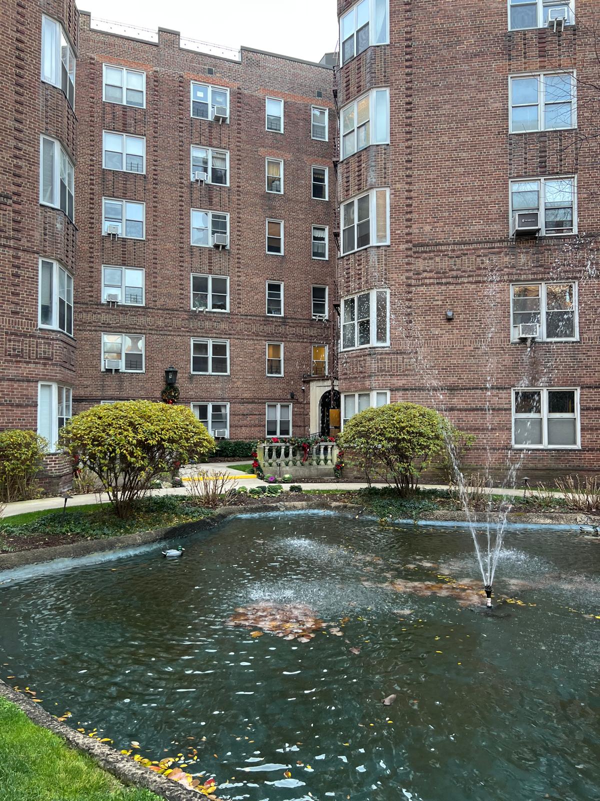 73-12 35th Avenue, Unit D56 Queens, NY 11372 - Photo 12 of 15 a view of a brick building next to a yard