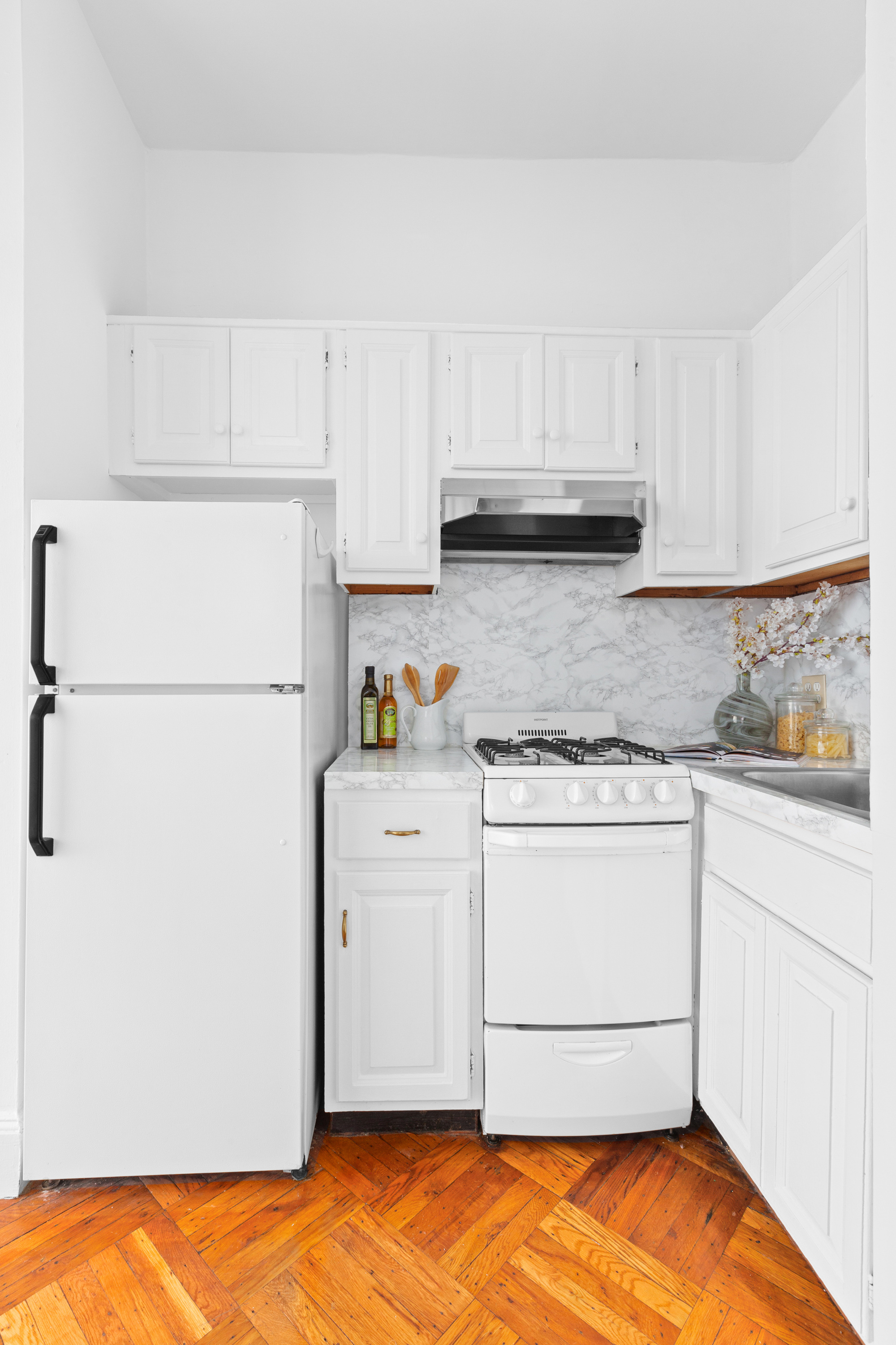 47 Reeve Place, Unit 1 Brooklyn, NY 11218 - Photo 4 of 8 a kitchen with white cabinets and white appliances