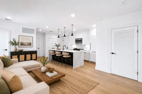 a living room with furniture and kitchen view