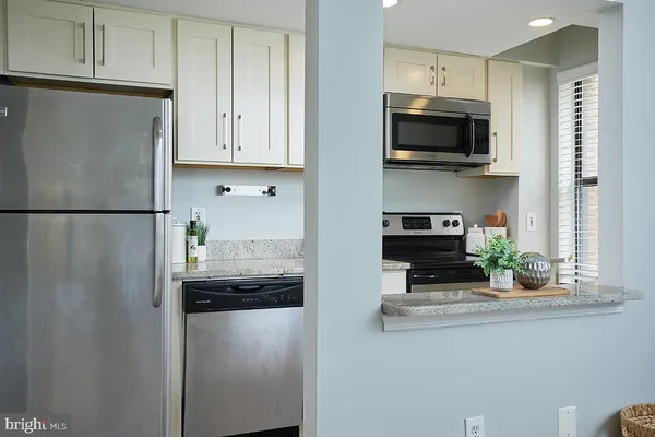 a kitchen with stainless steel appliances granite countertop a refrigerator and a microwave