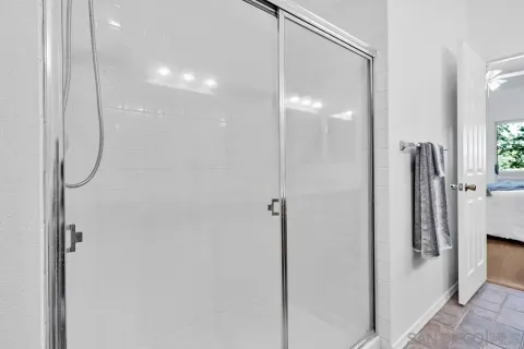 a spacious bathroom with a double vanity sink a large mirror and a shower