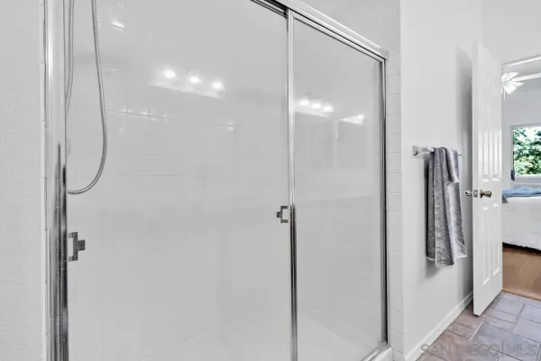 a spacious bathroom with a double vanity sink a large mirror and a shower