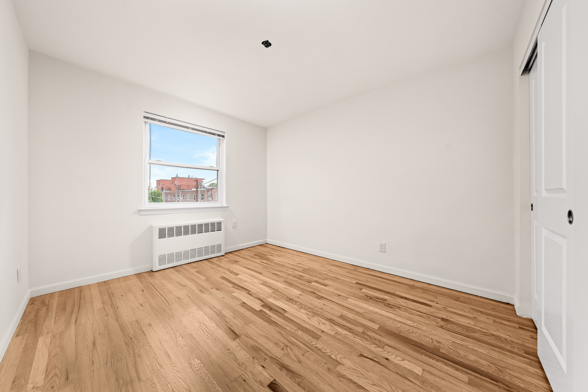 412 Fairview Avenue, Unit 2 Queens, NY 11385 - Photo 7 of 8 a view of a room with wooden floor and a window