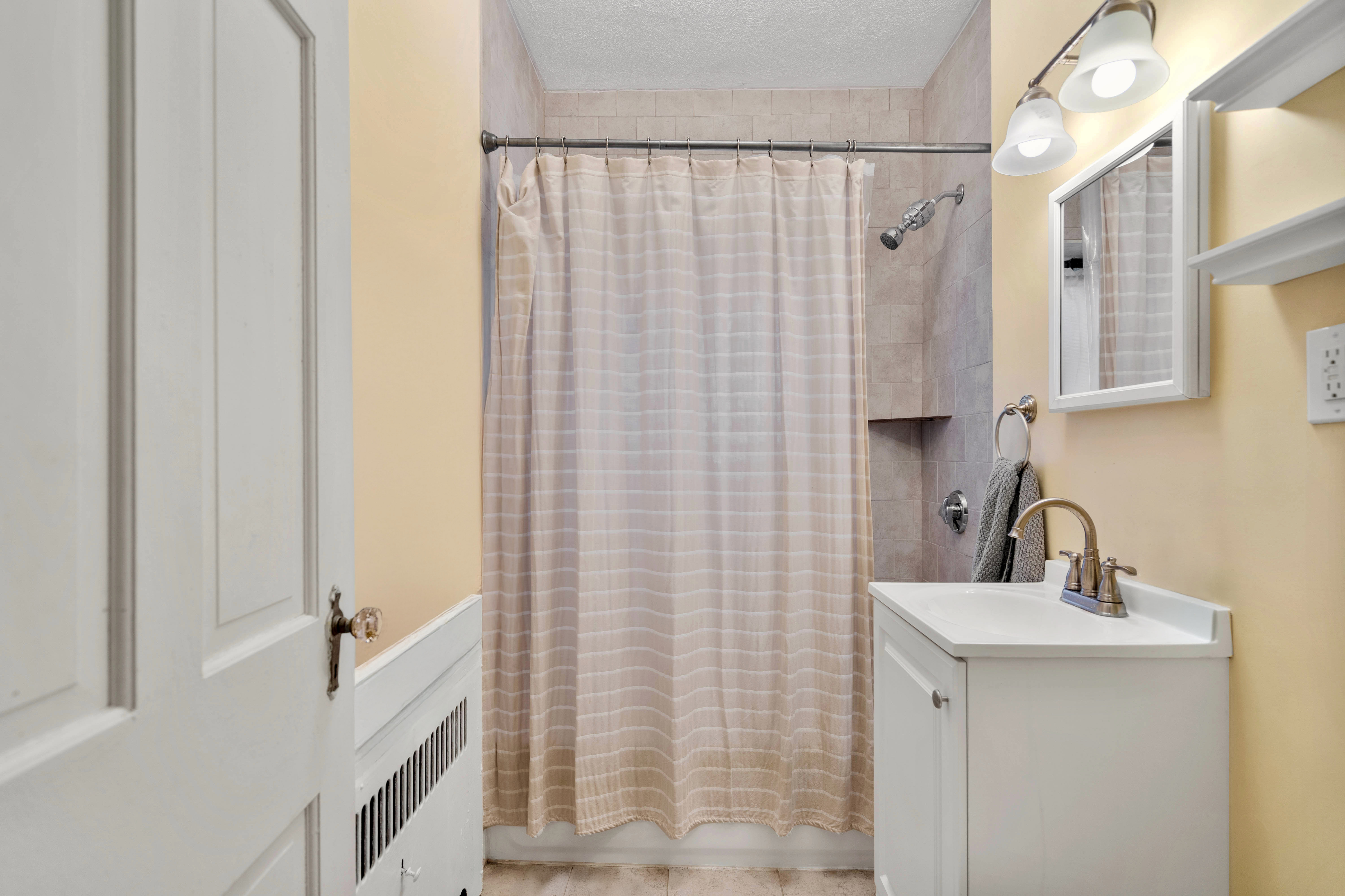 93 Strathmore Road, Unit 8 Brighton, MA 02135 - Photo 9 of 16 a bathroom with a shower curtain and a sink