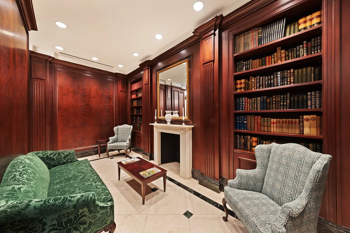 351 East 51st Street, Unit PH7A Manhattan, NY 10022 - Photo 7 of 14 a living room with furniture a bookshelf and a book shelf