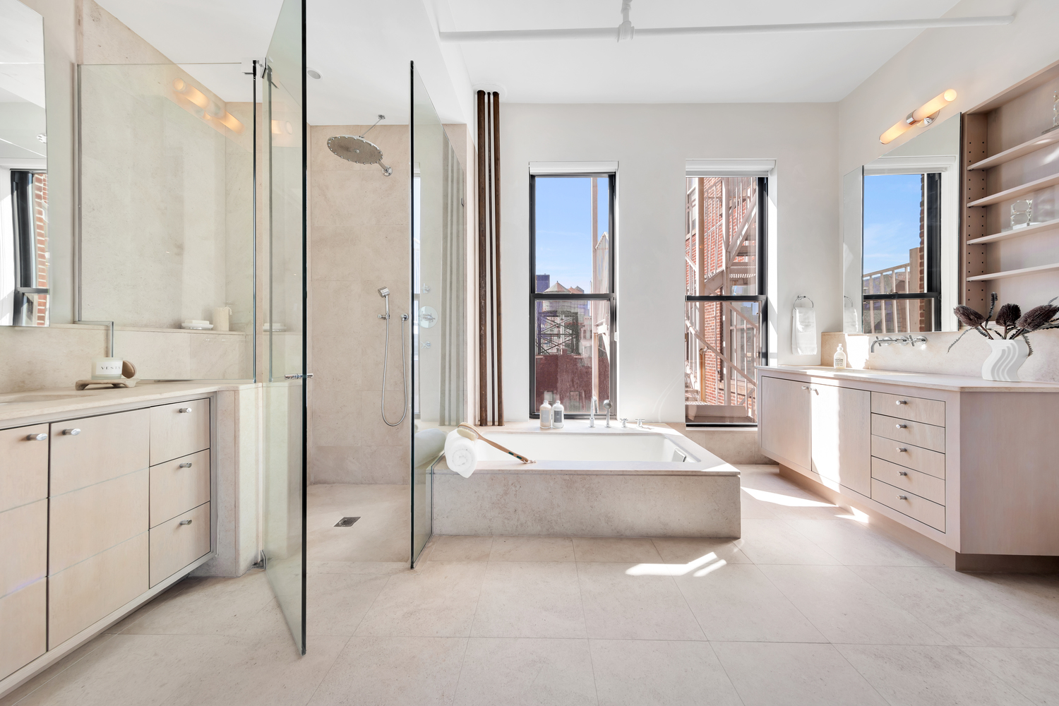 38 Crosby Street, Unit 8 Manhattan, NY 10013 - Photo 10 of 27 a spacious en suite bathroom with a double vanity sink a mirror and a bathtub