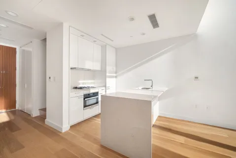 a kitchen with a sink cabinets stainless steel appliances and a window