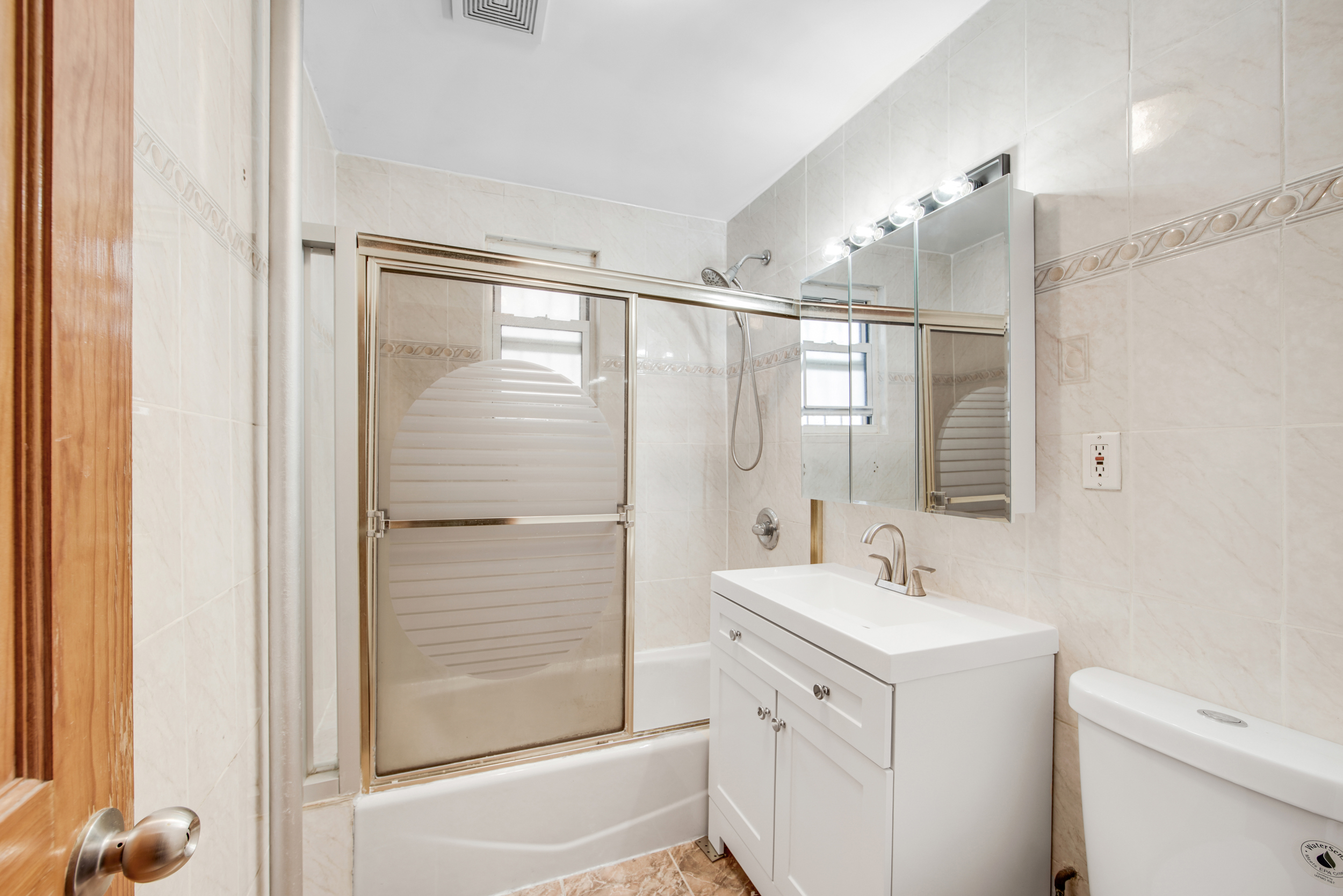 1759 West 1st Street Brooklyn, NY 11223 - Photo 16 of 21 a bathroom with a double vanity sink a mirror and a shower