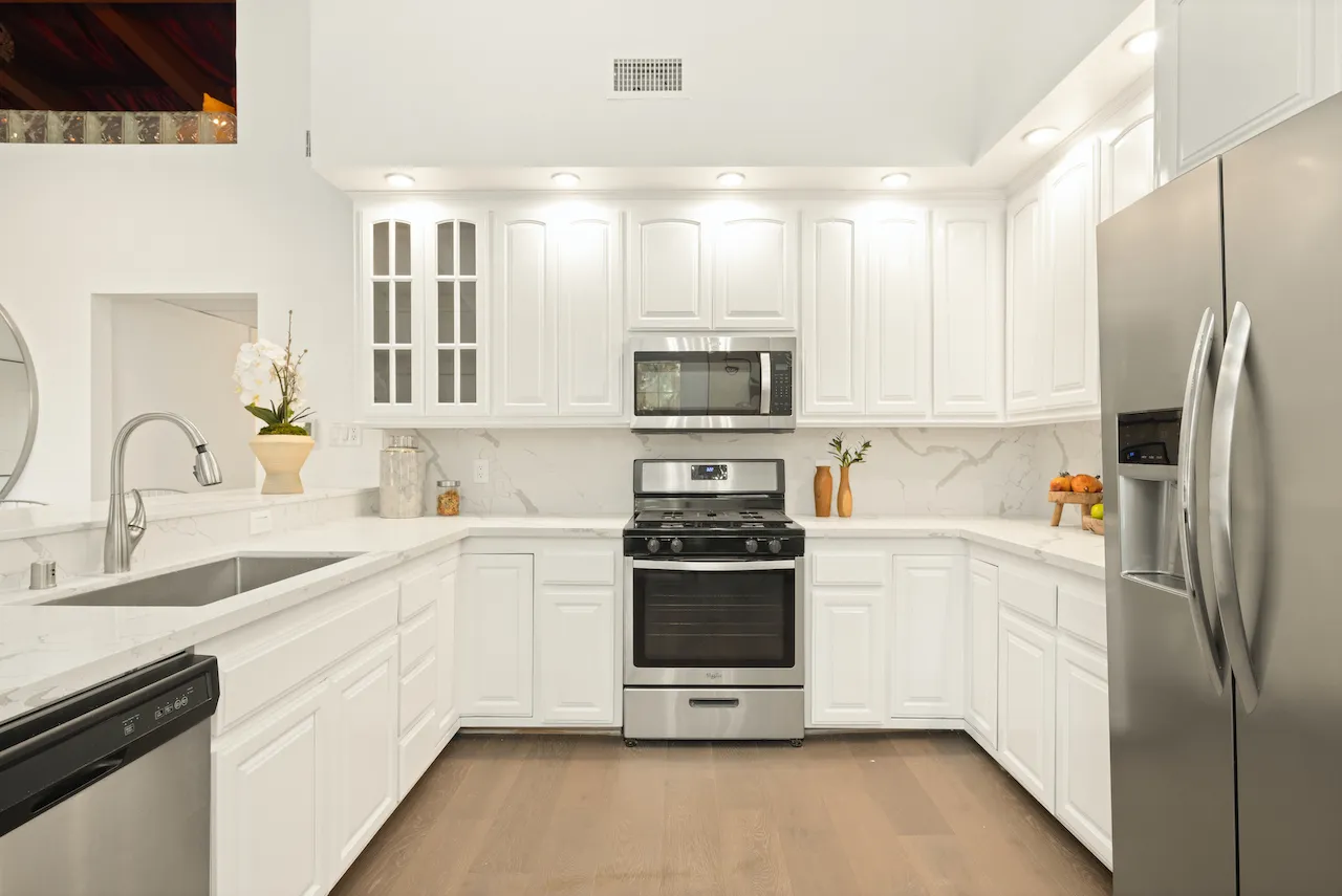 a kitchen with white cabinets and stainless steel appliances