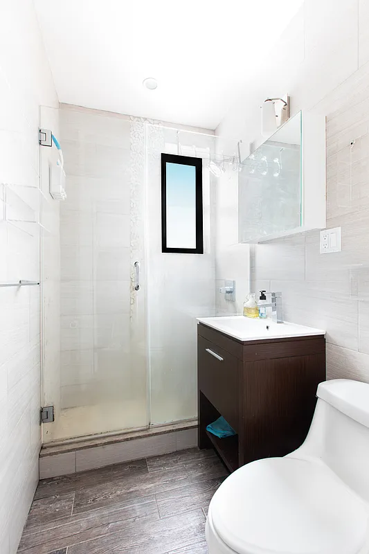 48 West 138th Street, Unit 5J Manhattan, NY 10037 - Photo 6 of 13 a bathroom with a sink mirror vanity and toilet