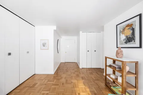 a view of a bedroom with wooden floor and bathroom