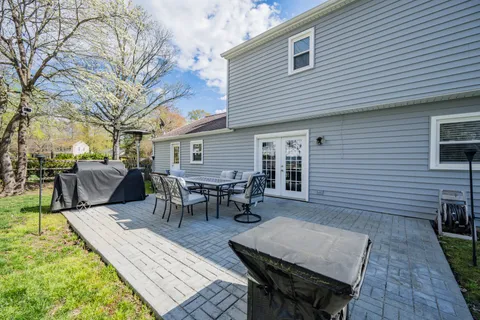a view of a patio with table and chairs with wooden floor and fence