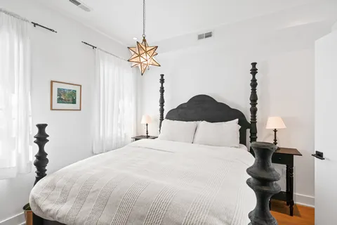 a bedroom with a bed and a chandelier
