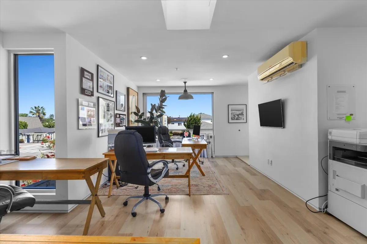 a workspace with furniture wooden floor and a flat screen tv