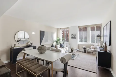 a living room with furniture a large window and dining table