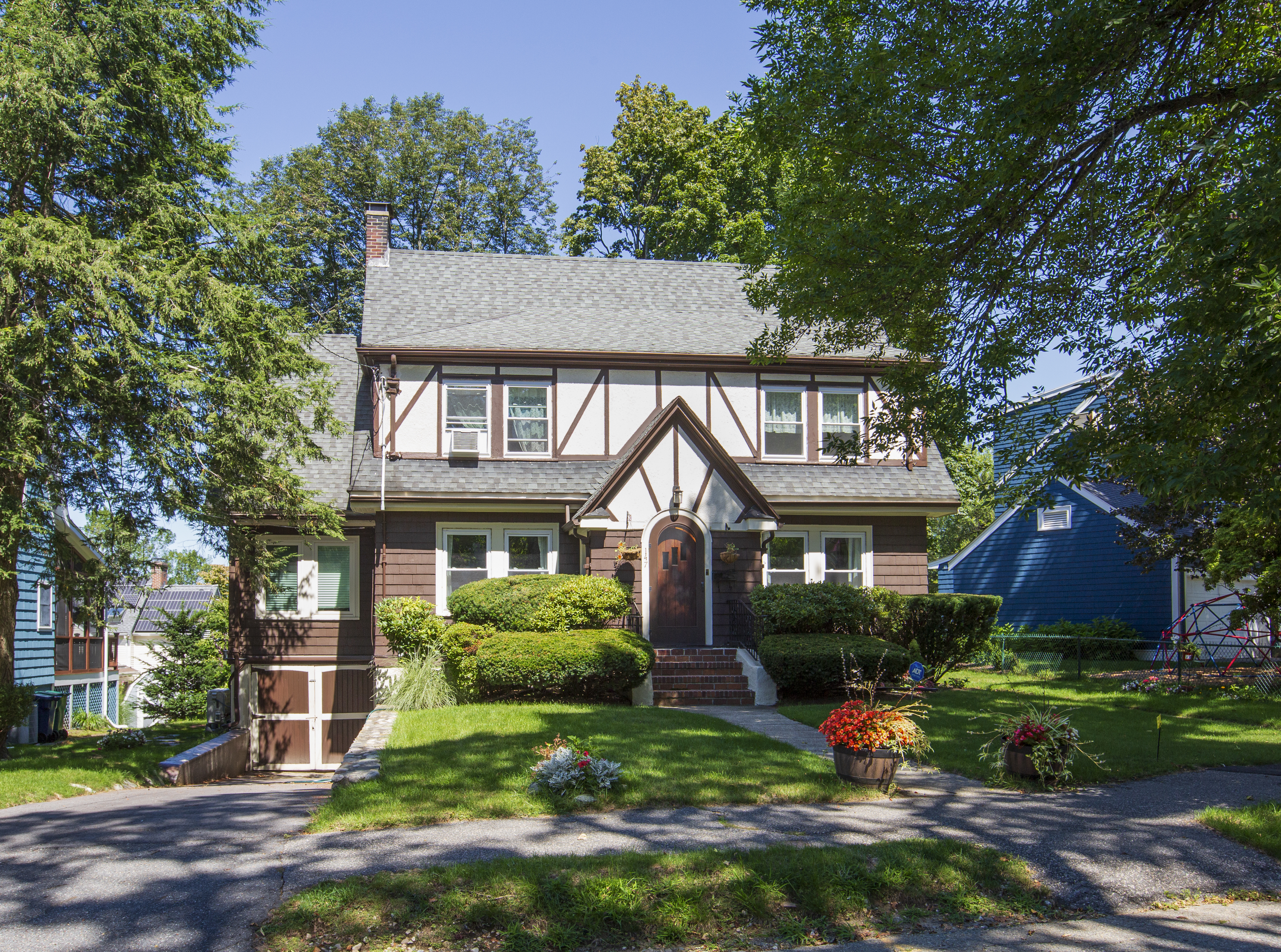 a front view of a house with a yard and green space