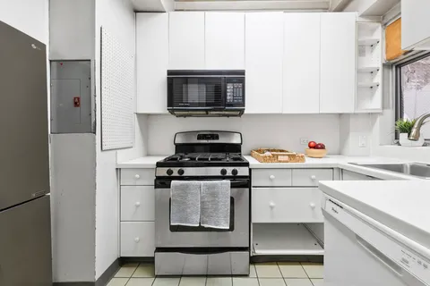 a kitchen with stainless steel appliances granite countertop a refrigerator stove and sink