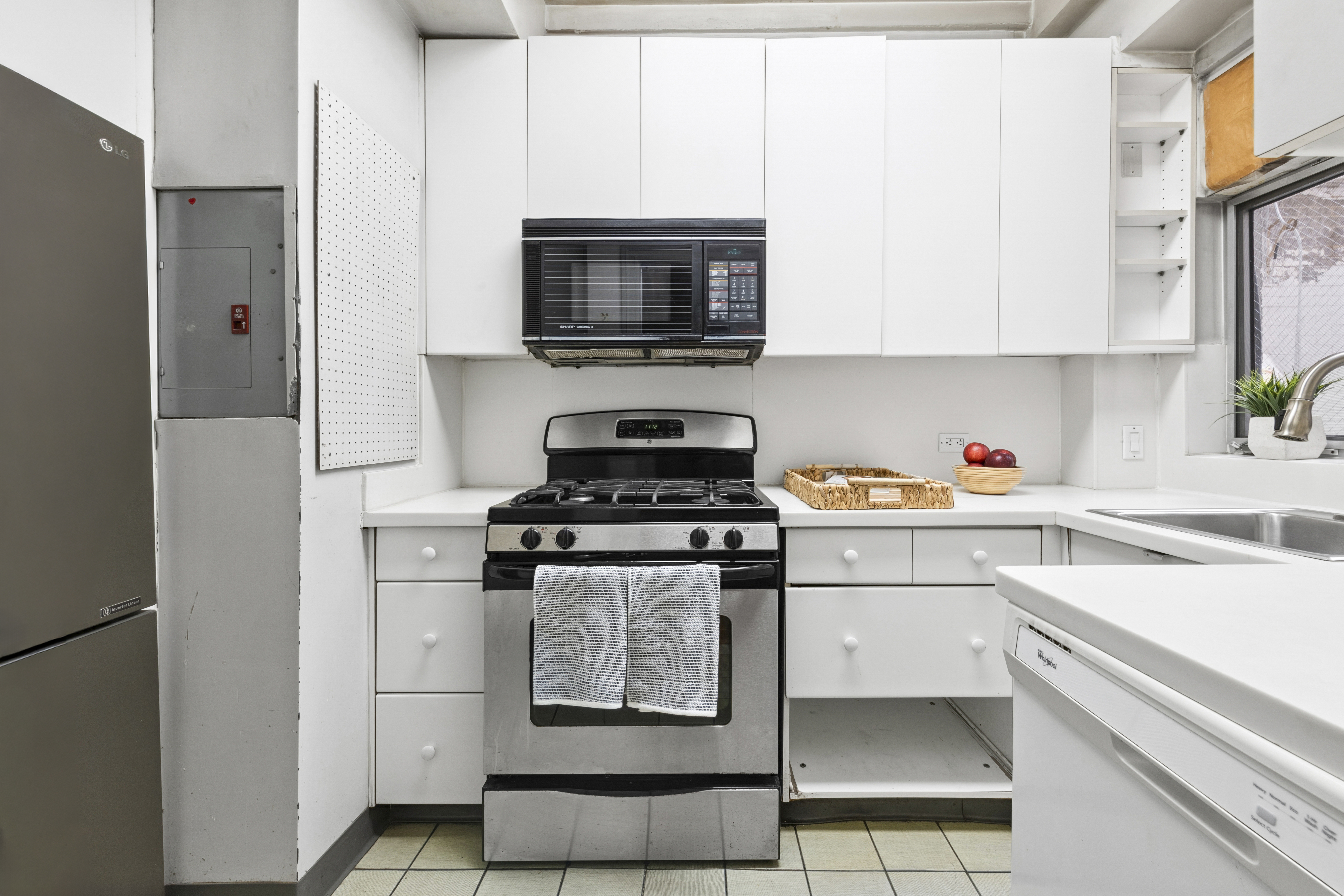 1 West 67th Street, Unit 303-304 Manhattan, NY 10023 - Photo 7 of 18 a kitchen with stainless steel appliances granite countertop a refrigerator stove and sink