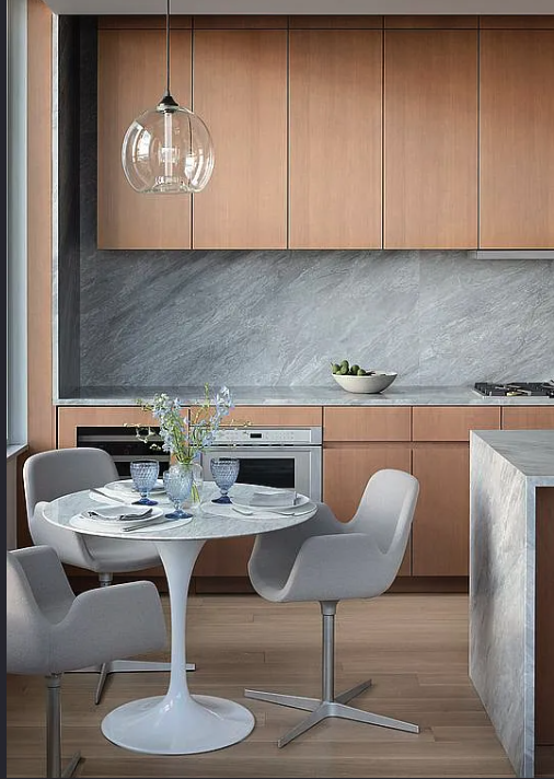 611 West 56th Street, Unit 6D Manhattan, NY 10019 - Photo 1 of 10 a kitchen with a table chairs and a refrigerator