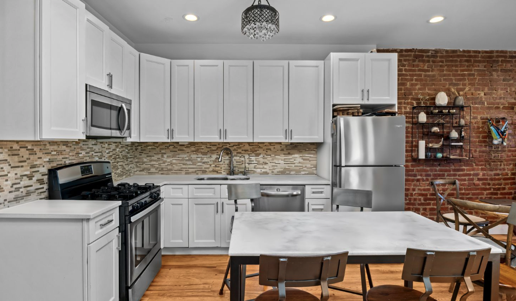 251 Troy Avenue Brooklyn, NY 11213 - Photo 5 of 9 a kitchen with kitchen island a refrigerator stove microwave and cabinets