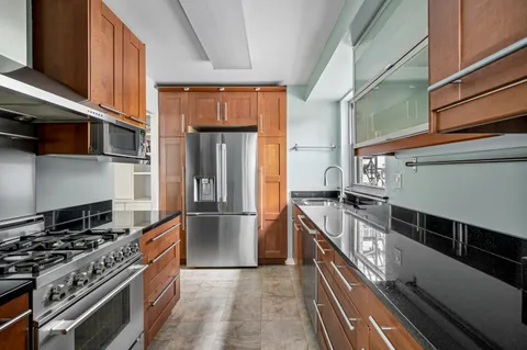 a kitchen with stainless steel appliances granite countertop a stove and a refrigerator