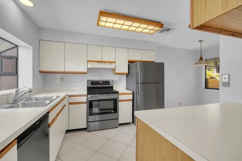 a kitchen with stainless steel appliances a refrigerator sink and stove