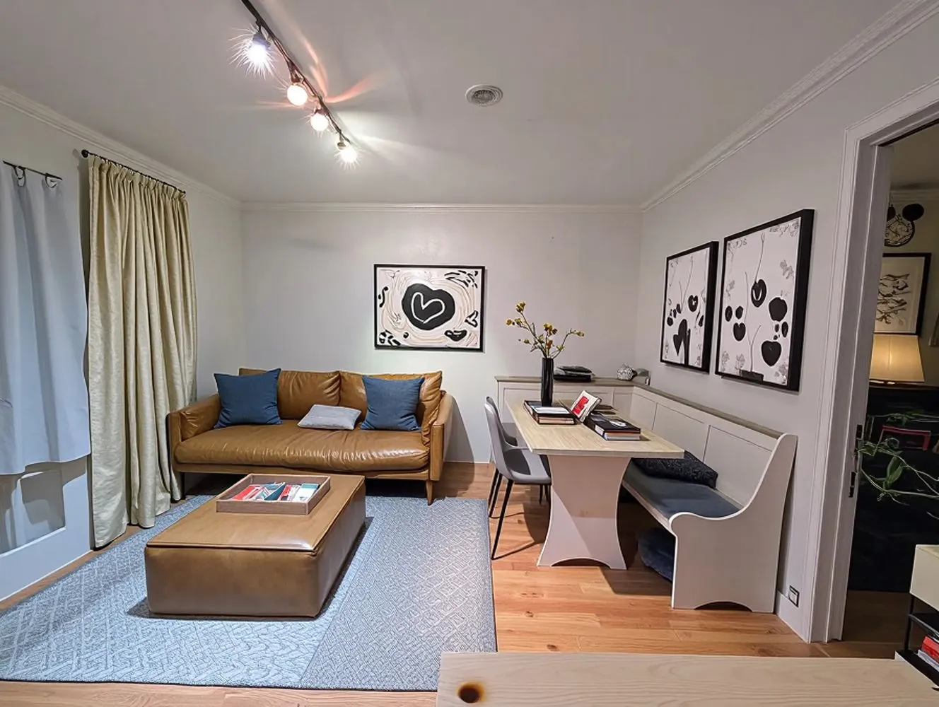 a living room with furniture and a painting on the wall