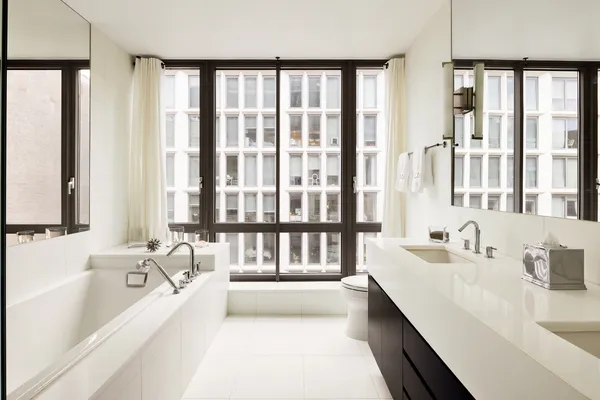 a bathroom with a tub a sink and a large window