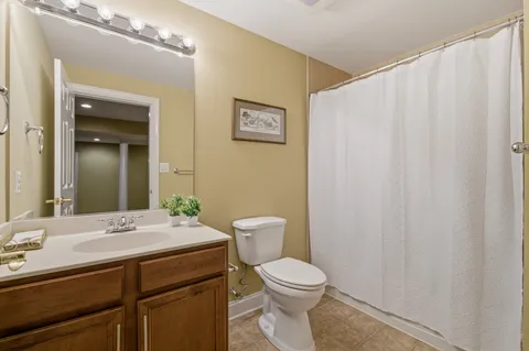 a bedroom with a bed a couch and a dresser next to a window