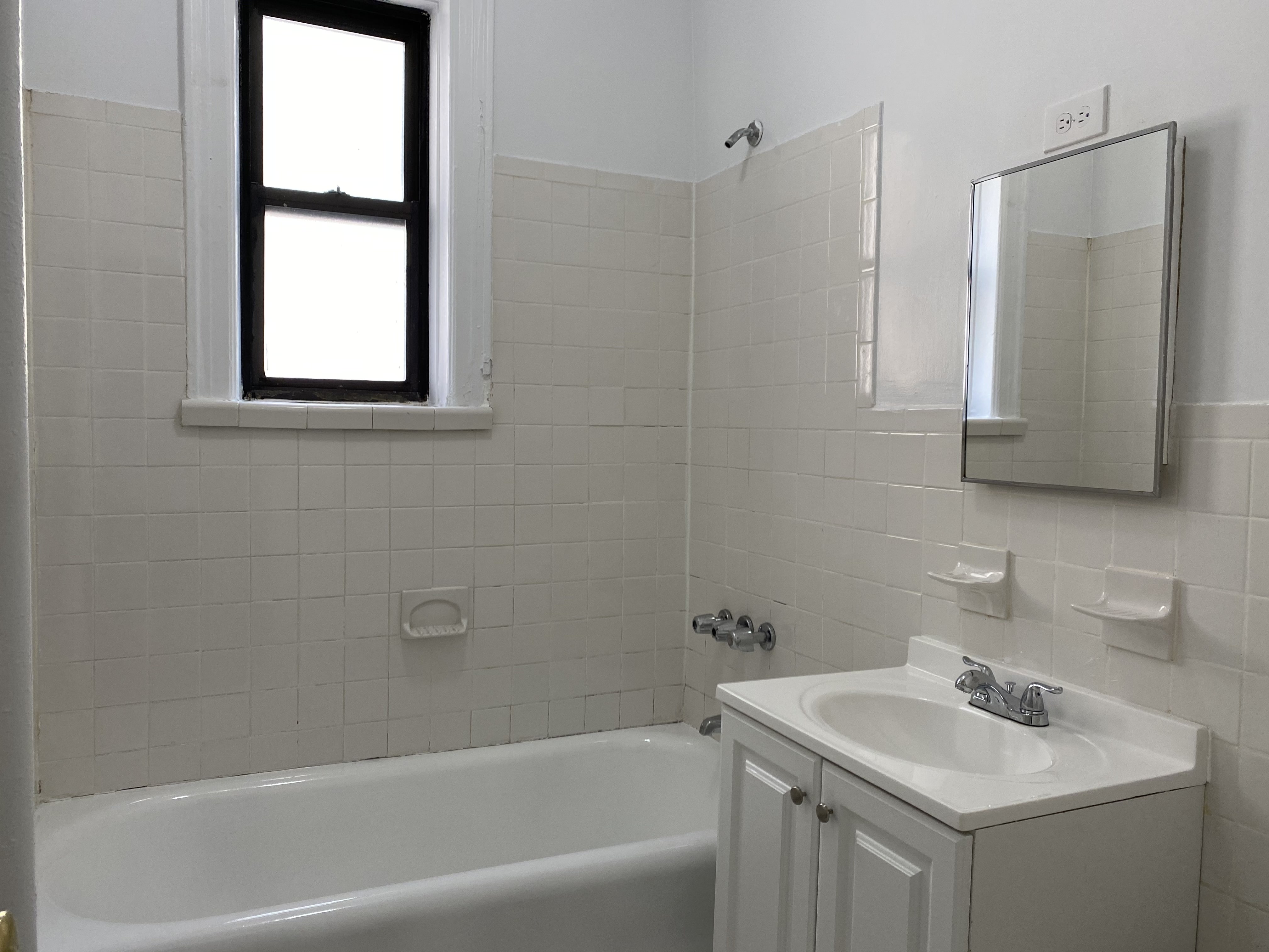 28-23 42nd Street, Unit C3 Queens, NY 11103 - Photo 6 of 6 a bathroom with a tub sink and mirror