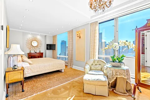 a living room with a bed furniture and a chandelier