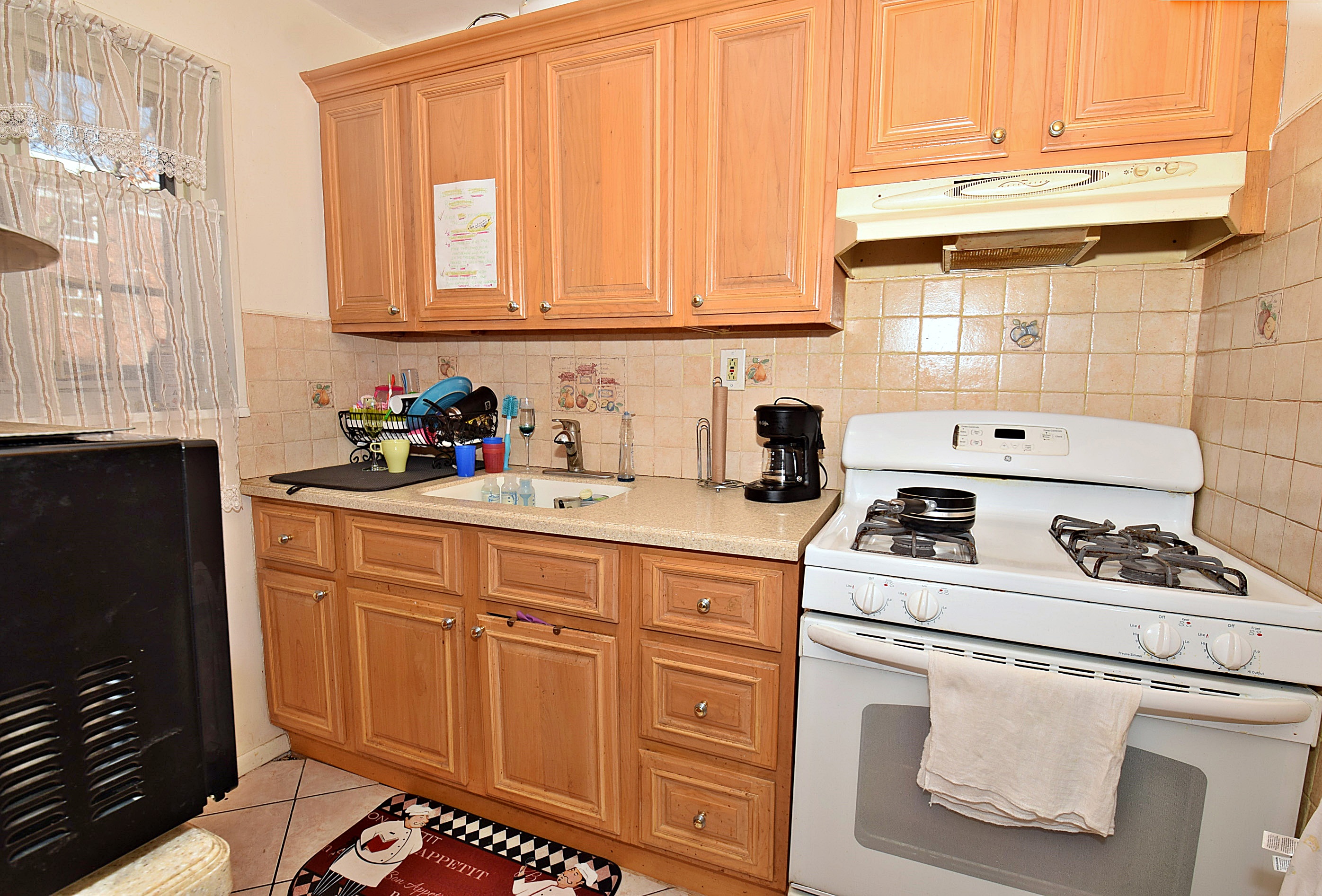 86-59 Springfield Boulevard, Unit U Queens, NY 11427 - Photo 2 of 6 a white kitchen with stainless steel appliances a stove a sink and cabinets