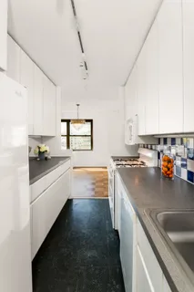 a kitchen with stainless steel appliances a sink dishwasher stove refrigerator and cabinets