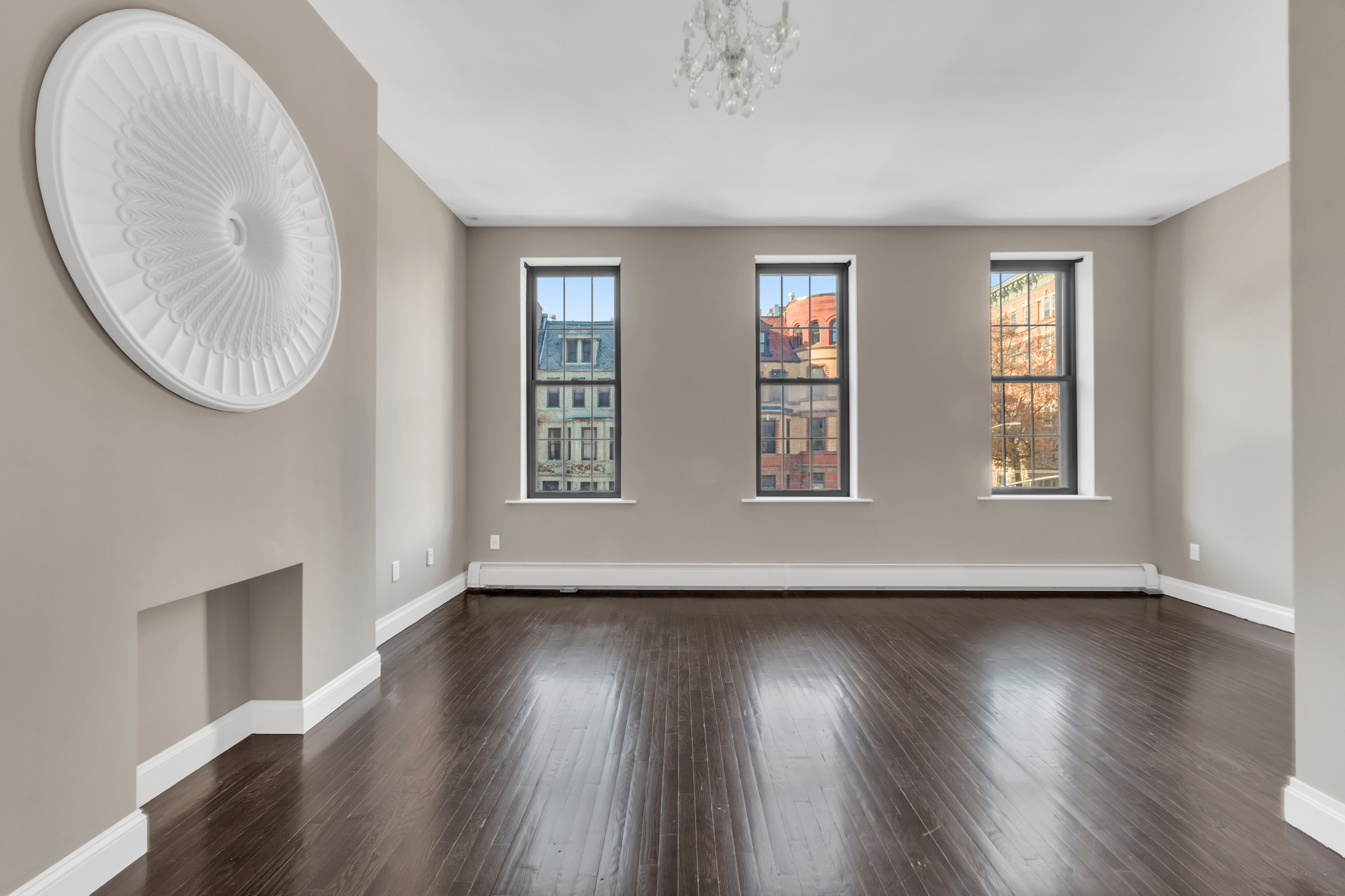 710 St Nicholas Avenue, Unit 2 Manhattan, NY 10031 - Photo 8 of 12 a view of an empty room with wooden floor and a window