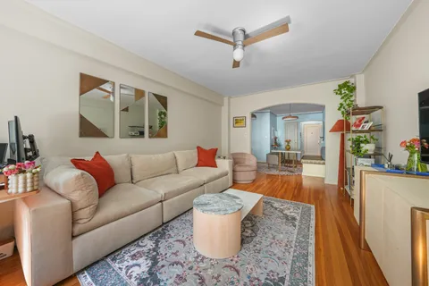 a living room with furniture and a wooden floor
