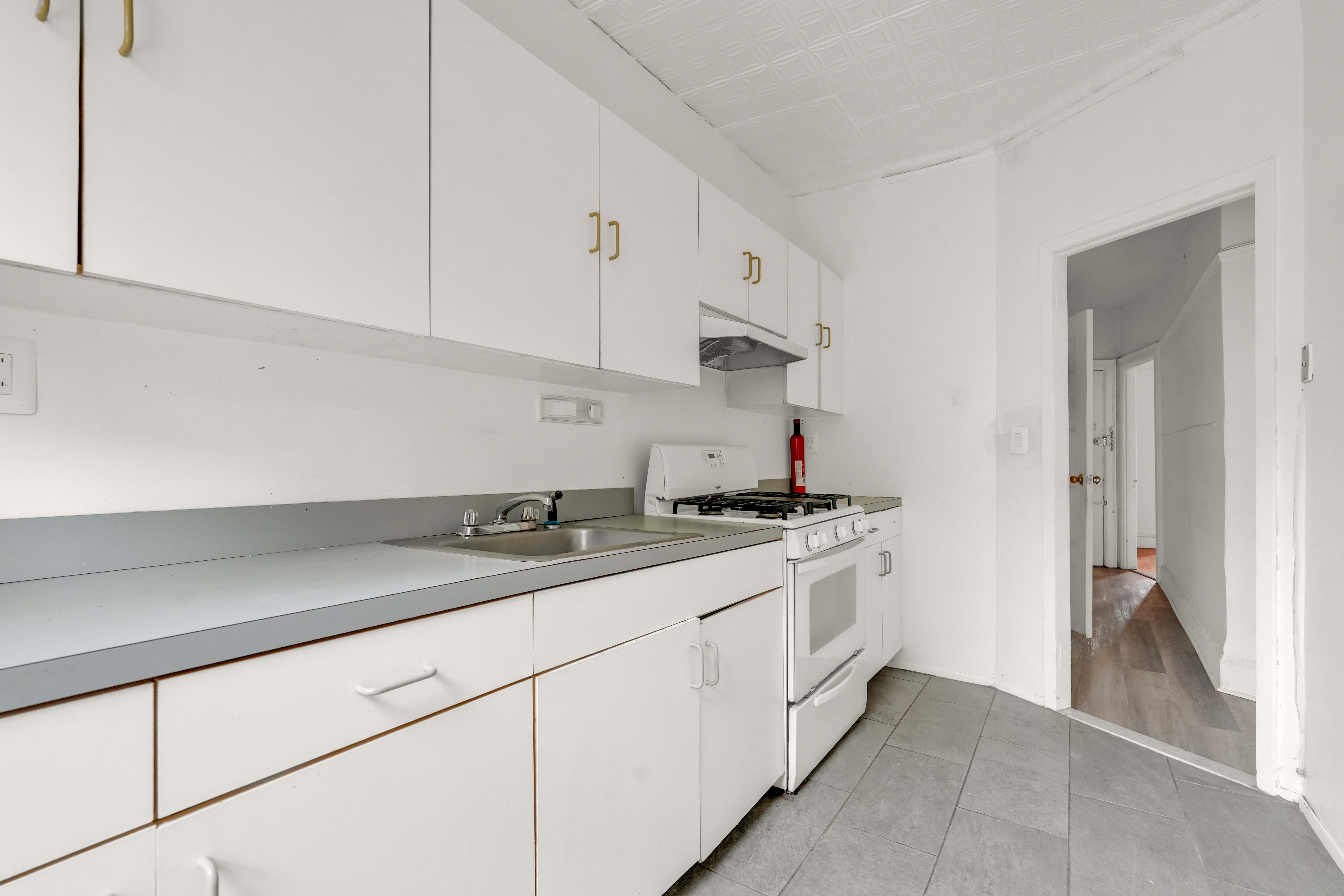 278 Lefferts Avenue Brooklyn, NY 11225 - Photo 14 of 56 a kitchen with granite countertop white cabinets and a sink