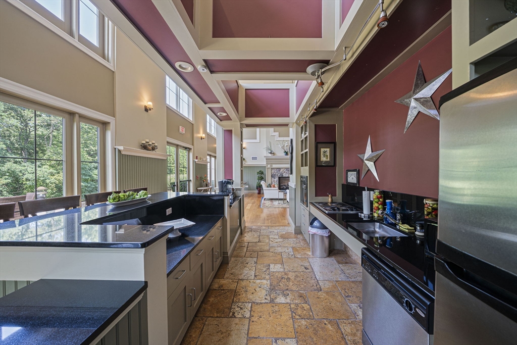 59 Walpole Street, Unit 210 Canton, MA 02021 - Photo 29 of 42 a kitchen with stainless steel appliances kitchen island granite countertop a stove and a refrigerator