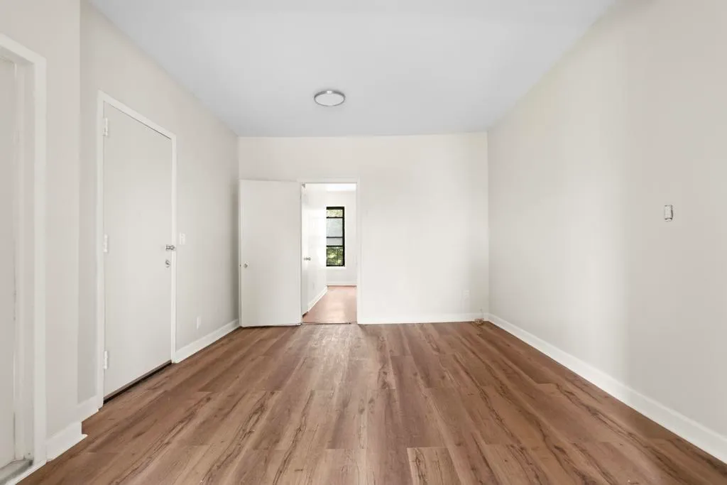 a view of a room with wooden floor and windows